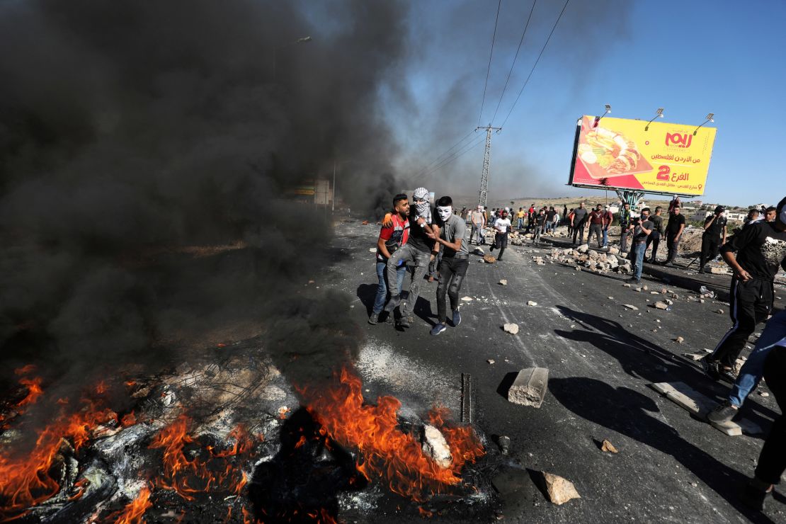 Palestinian demonstrators evacuate a wounded man during clashes with Israeli forces near the Jewish settlement of Beit El.