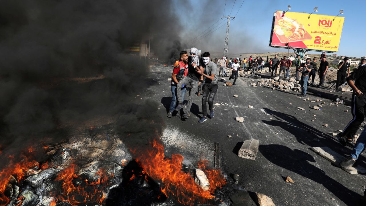 Palestinian demonstrators evacuate a wounded man during clashes with Israeli forces near the Jewish settlement of Beit El.