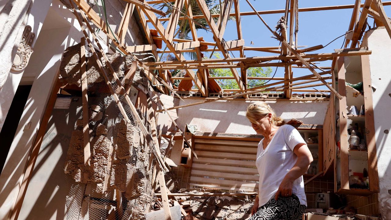 An Israeli woman inspects the damage to her house following a rocket attack from Gaza, in the southern Israeli city of Sderot, on May 15.