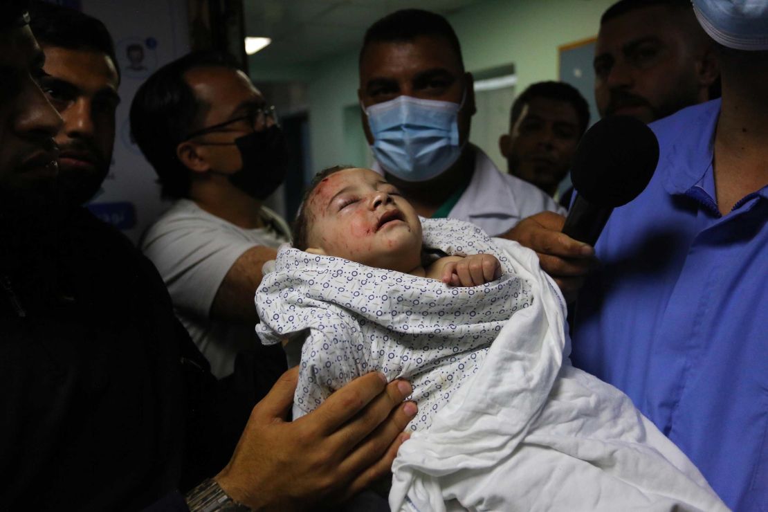 A baby is brought to Shifa Hospital in Gaza City for treatment on May 15, after being injured in an Israeli airstrike, which destroyed a 3-story house and killed 10 members of the child's family.