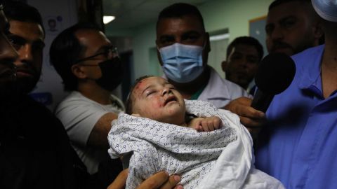 A baby is brought to Shifa Hospital in Gaza City for treatment on May 15, after being injured in an Israeli airstrike, which destroyed a 3-story house and killed 10 members of the child's family.