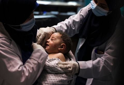 A nurse holds an injured baby at Al-Shifa Hospital in Gaza City on May 15. The baby was pulled alive from a building destroyed by an Israeli airstrike, which killed 10 members of the child's family.
