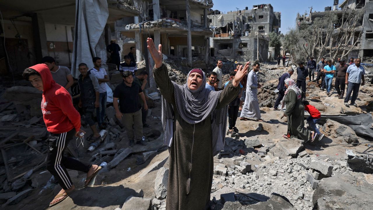 A Palestinian woman reacts as people assess the damage caused by Israeli air strikes in Beit Hanun, Gaza, on Friday, May 14.