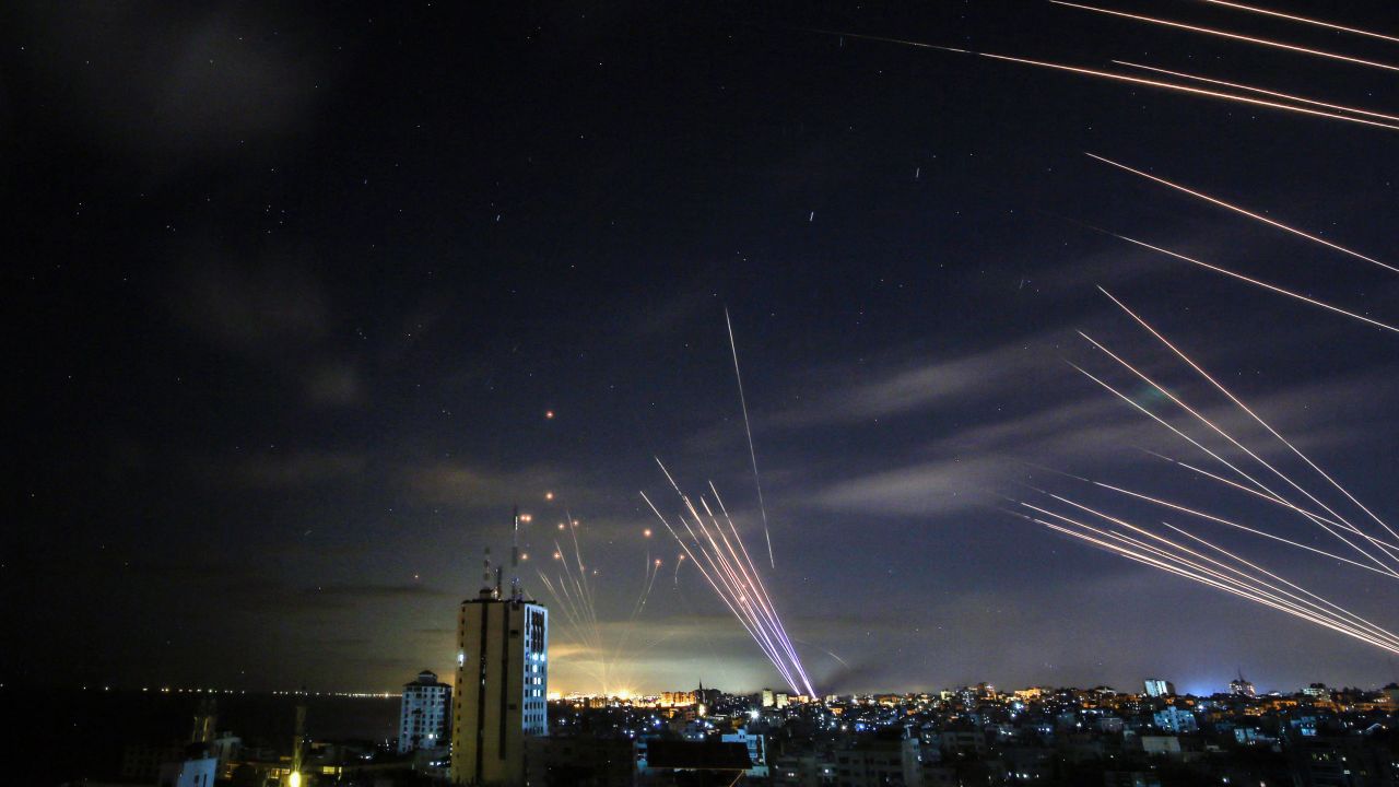 In the background, the Israeli Iron Dome missile defense system intercepts rockets fired by Hamas toward southern Israel from Beit Lahia, in northern Gaza, on May 16.