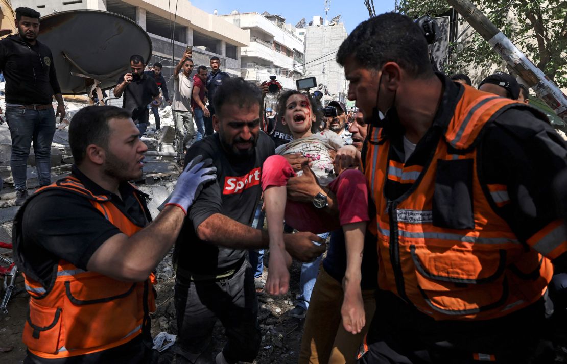 Palestinian paramedics evacuate a girl from the rubble of a building that was destroyed by an Israeli airstrike in Gaza's al-Rimal residential district on May 16.