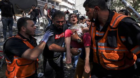 Palestinian paramedics evacuate a girl from the rubble of a building that was destroyed by an Israeli airstrike in Gaza's al-Rimal residential district on May 16.