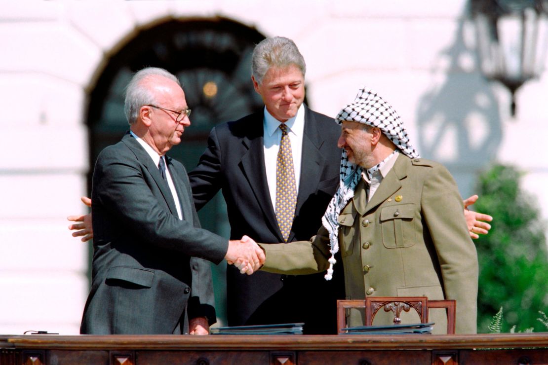 US President Bill Clinton watches as Israeli Prime Minister Yitzhak Rabin, left, and PLO leader Yasser Arafat shake hands on September 13, 1993 at the White House after signing the Oslo Accords.