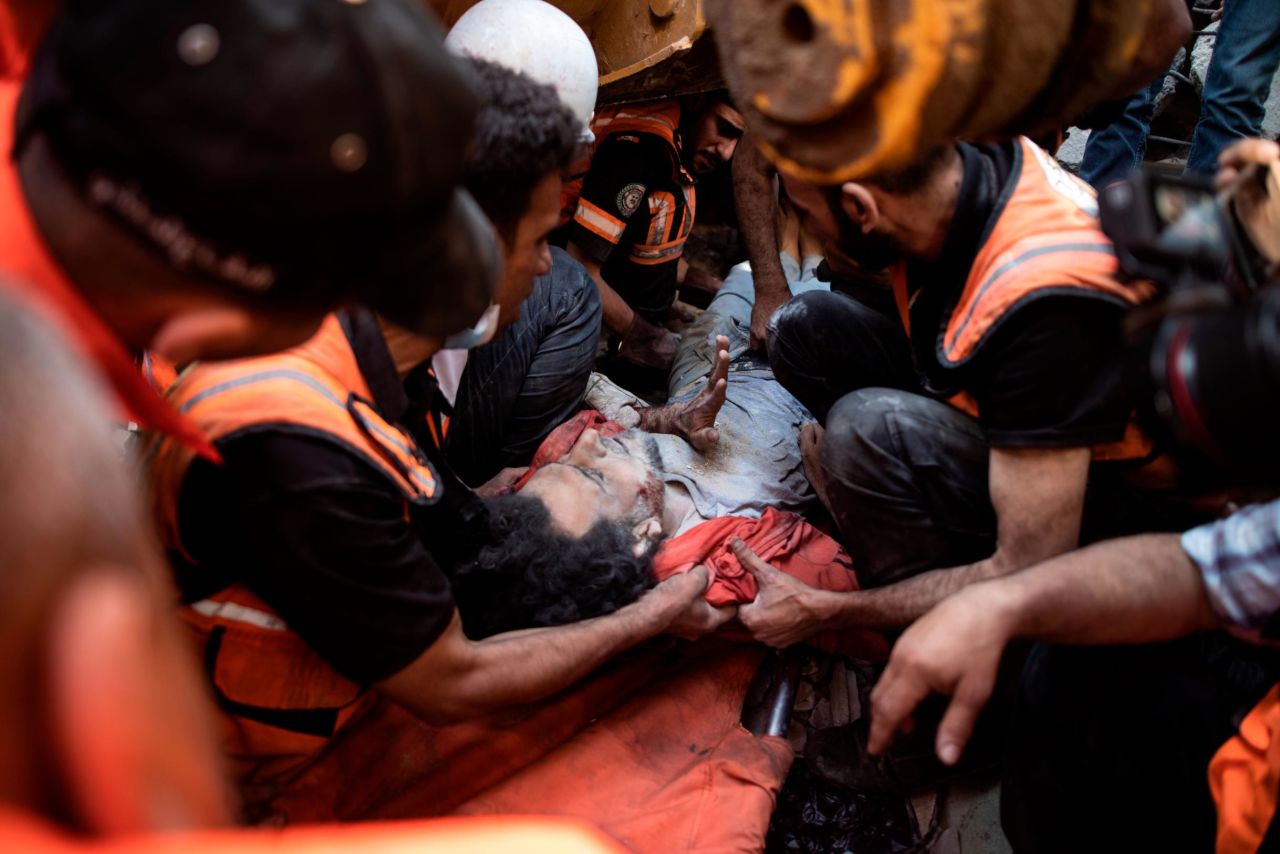 Palestinian rescuers pull a survivor from the rubble of a building that was destroyed by an Israeli airstrike in Gaza City on Sunday, May 16.