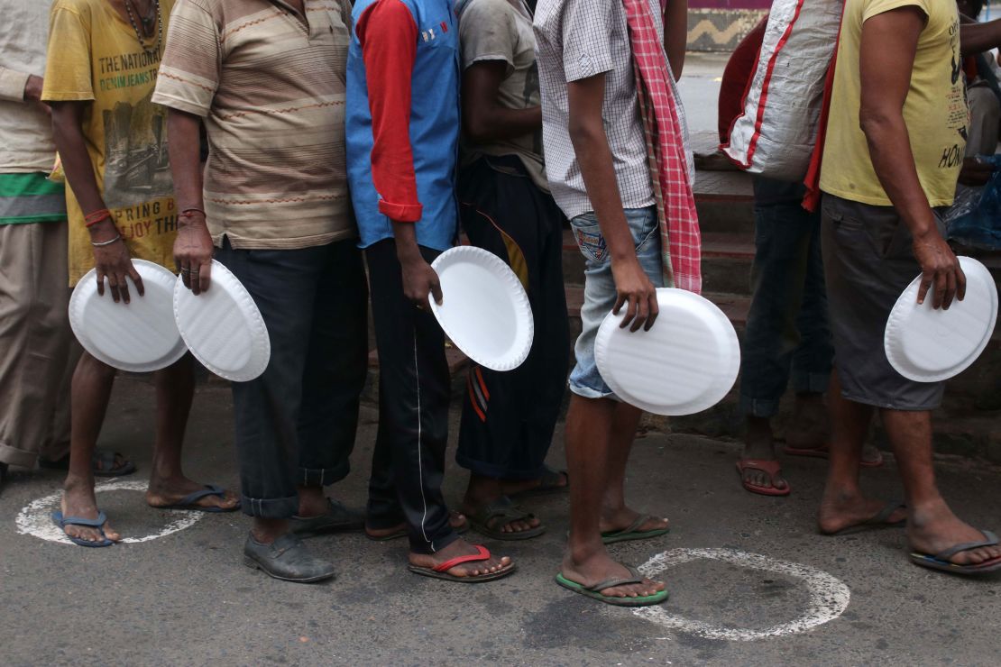 Underprivileged people wait to receive free food in Kolkata, India, on August 27, 2020.  