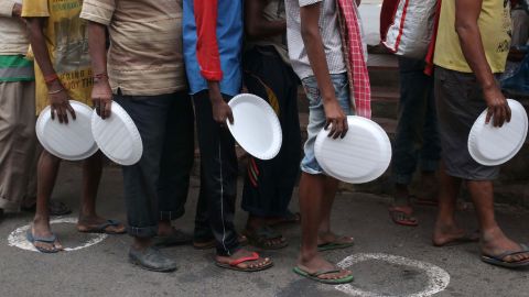 Underprivileged people wait to receive free food in Kolkata, India, on August 27, 2020.  
