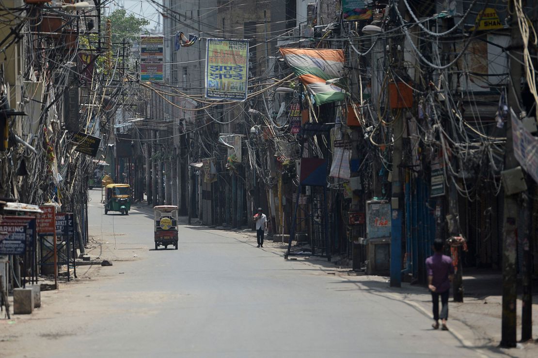 People walk through a deserted alley during a lockdown imposed by the government amid rising Covid-19 cases, in New Delhi on May 16, 2021. 