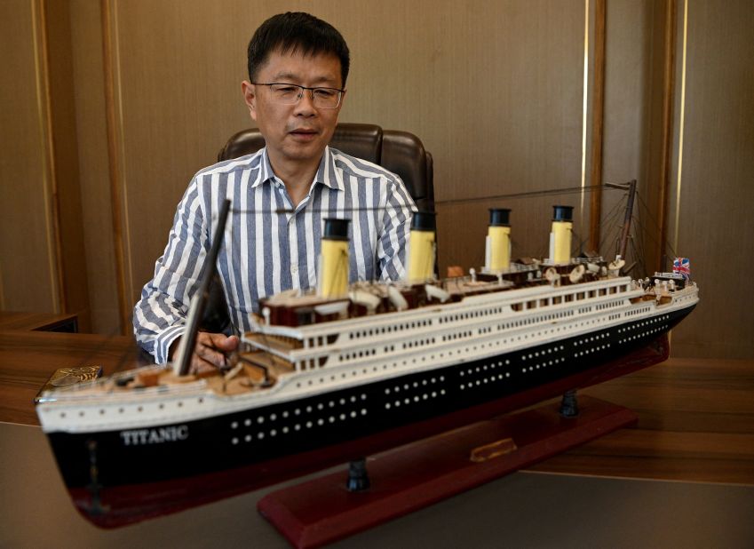 <strong>Model of the ship:</strong> Su Shaojun, an investor helping to build the life-size replica, sits next to a model of the ship during an interview with AFP at his office in Daying county. 