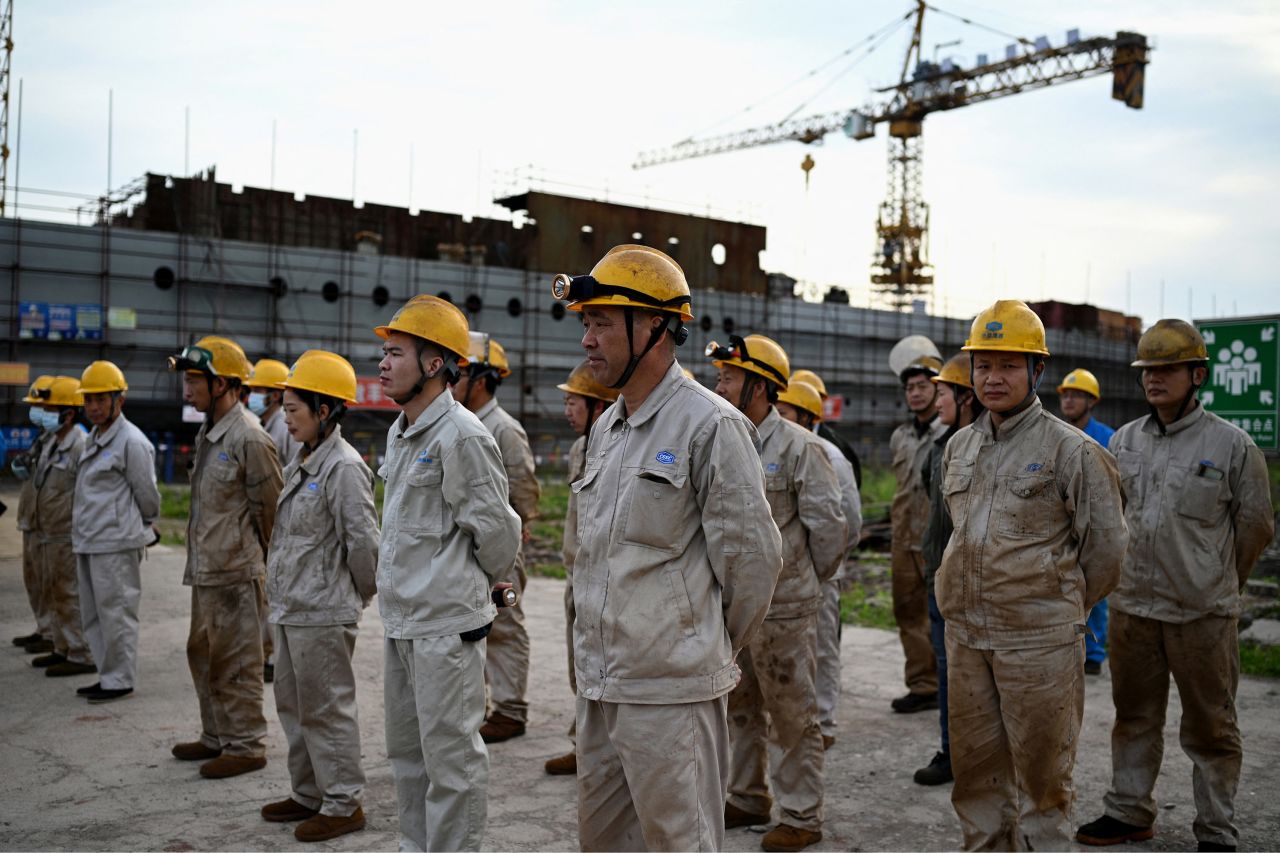 <strong>Building site: </strong>Workers line up before the start of work at the site of the replica, which will be the centerpiece of a theme park where tourists can splash out for a night on the true-to-size vessel. 