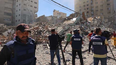 Journalists work near the destroyed Al-Jala'a building, which housed international press offices, following an Israeli airstrike in Gaza on Saturday, May 15.