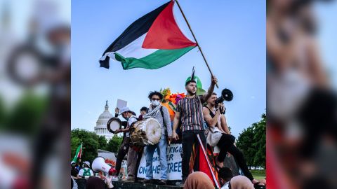 A protester raises a Palestinian flag while riding on a tank-shaped float pushed by marchers along Pennsylvania Avenue, on the west side of the Capitol, on May 15.