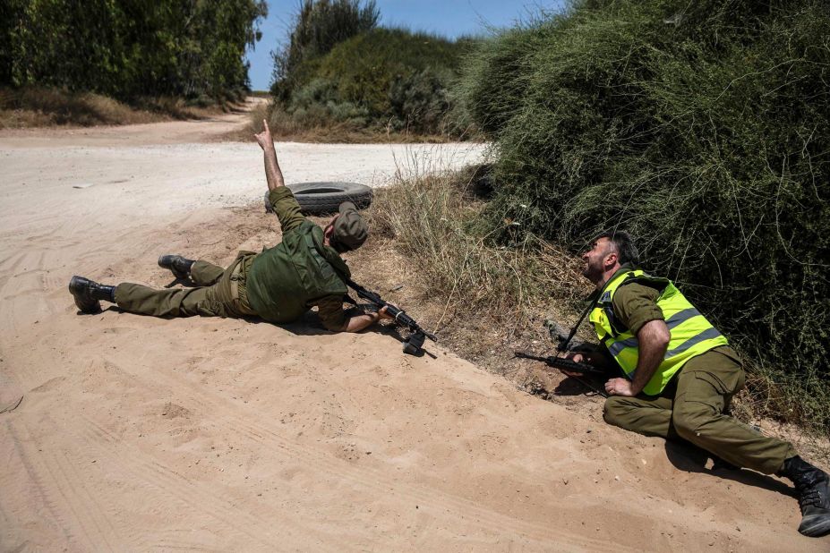 Israeli soldiers take cover near the Gaza border as a siren warns them about incoming rockets on May 17.