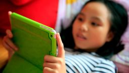 Girl playing with her tablet during a Pokemon Go gaming. | usage worldwide Photo by: Fred de Noyelle / Godong/picture-alliance/dpa/AP Images