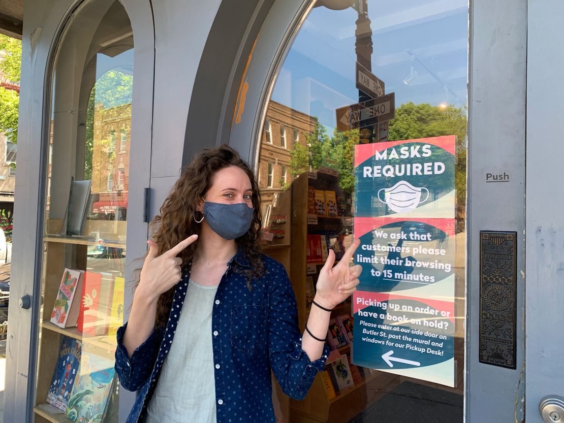 Colleen Callery, marketing director at Books are Magic in Brooklyn, stood next to the store's "masks required sign," which will remain despite the CDC change in mask guidance last week.