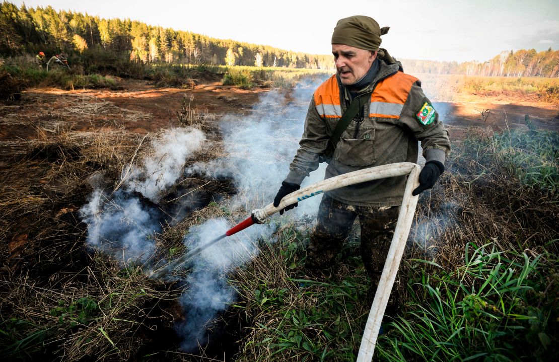 A local activist extinguishes a fire in the village of Shipunovo, Siberia. 