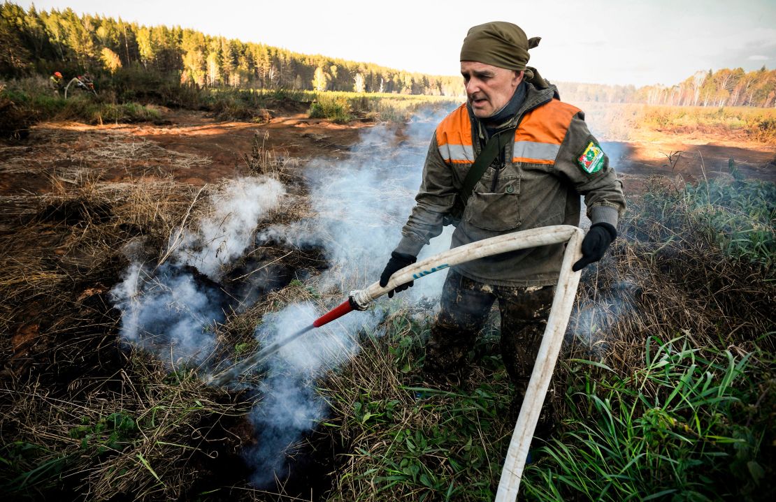A local activist extinguishes a fire in the village of Shipunovo, Siberia.