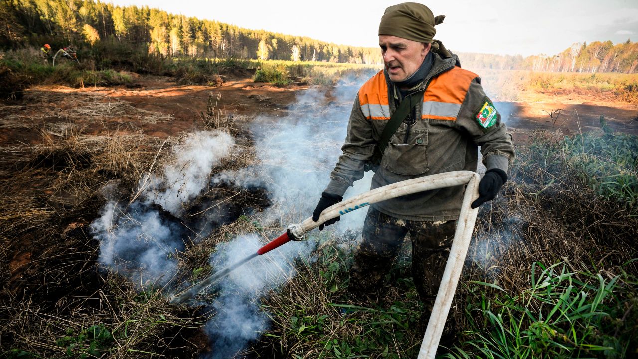 A local activist extinguishes a fire in the village of Shipunovo, Siberia. 