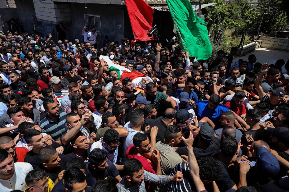 Palestinian mourners carry the body of Obaida Jawabreh, who was killed amid clashes with Israeli forces, during his funeral in the West Bank refugee camp of Al-Arrub on May 18.