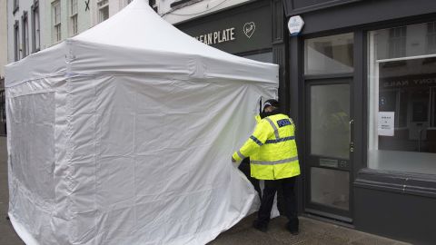 An officer is seen outside the Clean Plate cafe on Southgate Street on May 11 in Gloucester, as police search for remains of the missing girl Mary Bastholm.