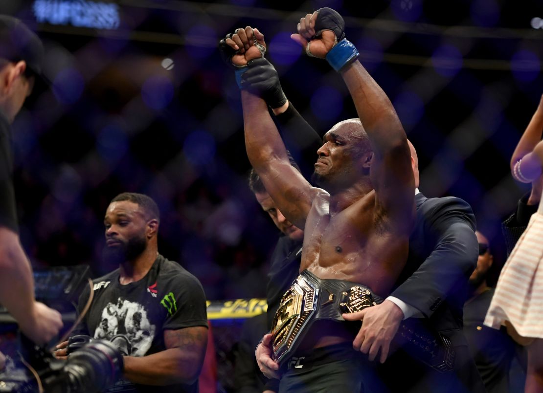 Usman has the welterweight championship belt placed around his waist after defeating Woodley.