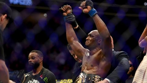 Usman has the welterweight championship belt placed around his waist after defeating Woodley.
