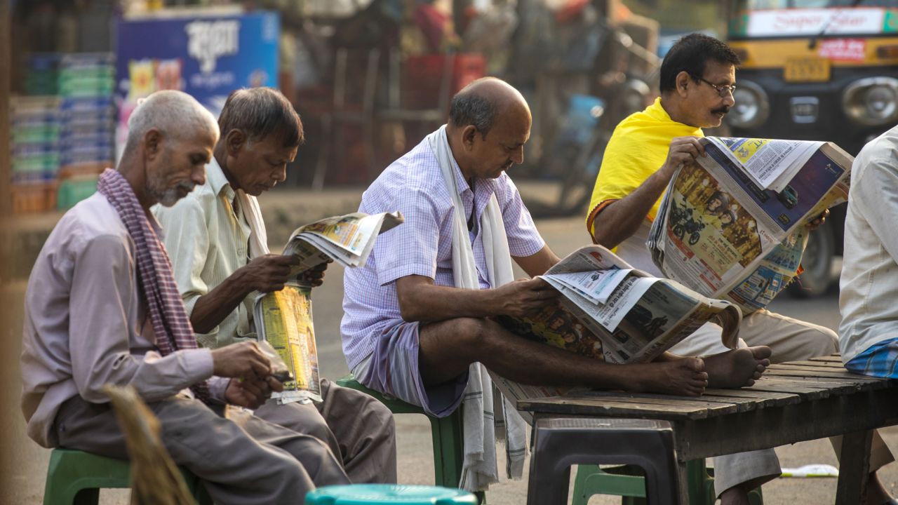 People read newspapers at a roadside tea stall in Patna, Bihar, India, on October 22, 2020.
