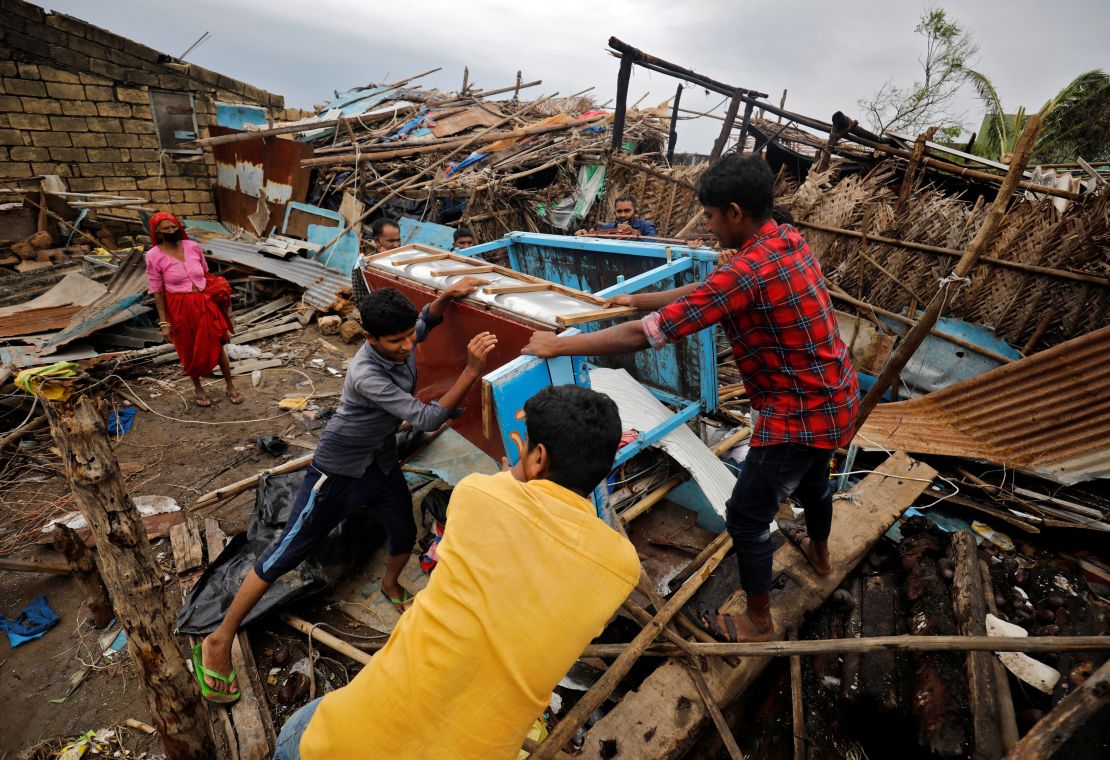 People salvage their belongings from a damaged house after cyclone Tauktae hit in the western state of Gujarat, India.