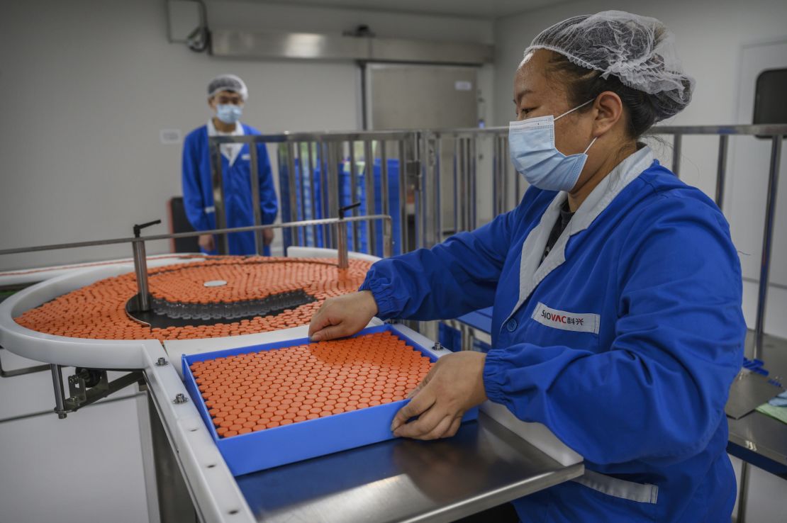A worker handles vials on the production line at Sinovac Biotech in Beijing, China.