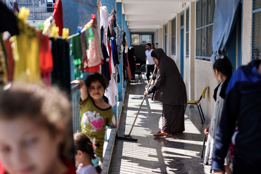 A displaced Palestinian woman cleans outside classrooms that are being used to host families who fled their homes for safety at a school in Gaza City on May 18.