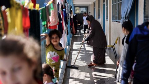 A displaced Palestinian woman cleans outside classrooms that are being used to host families who fled their homes for safety at a school in Gaza City on May 18.