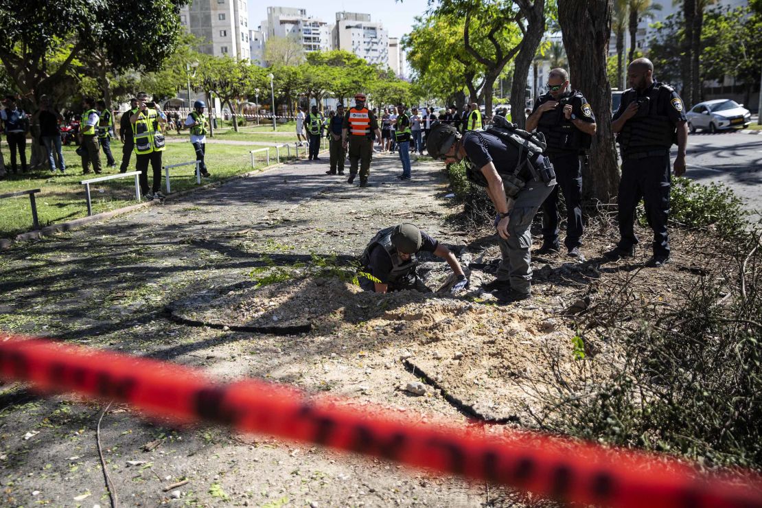 An Israeli bomb squad unit inspect the site where a rocket fired from Gaza hit a sidewalk in Ashdod, Israel, on Wednesday, May 19.