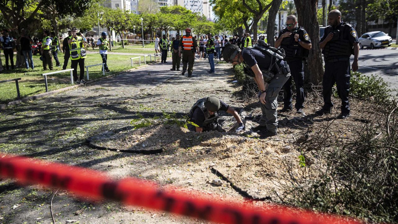 An Israeli bomb squad unit inspect the site where a rocket fired from Gaza hit a sidewalk in Ashdod, Israel, on Wednesday, May 19.