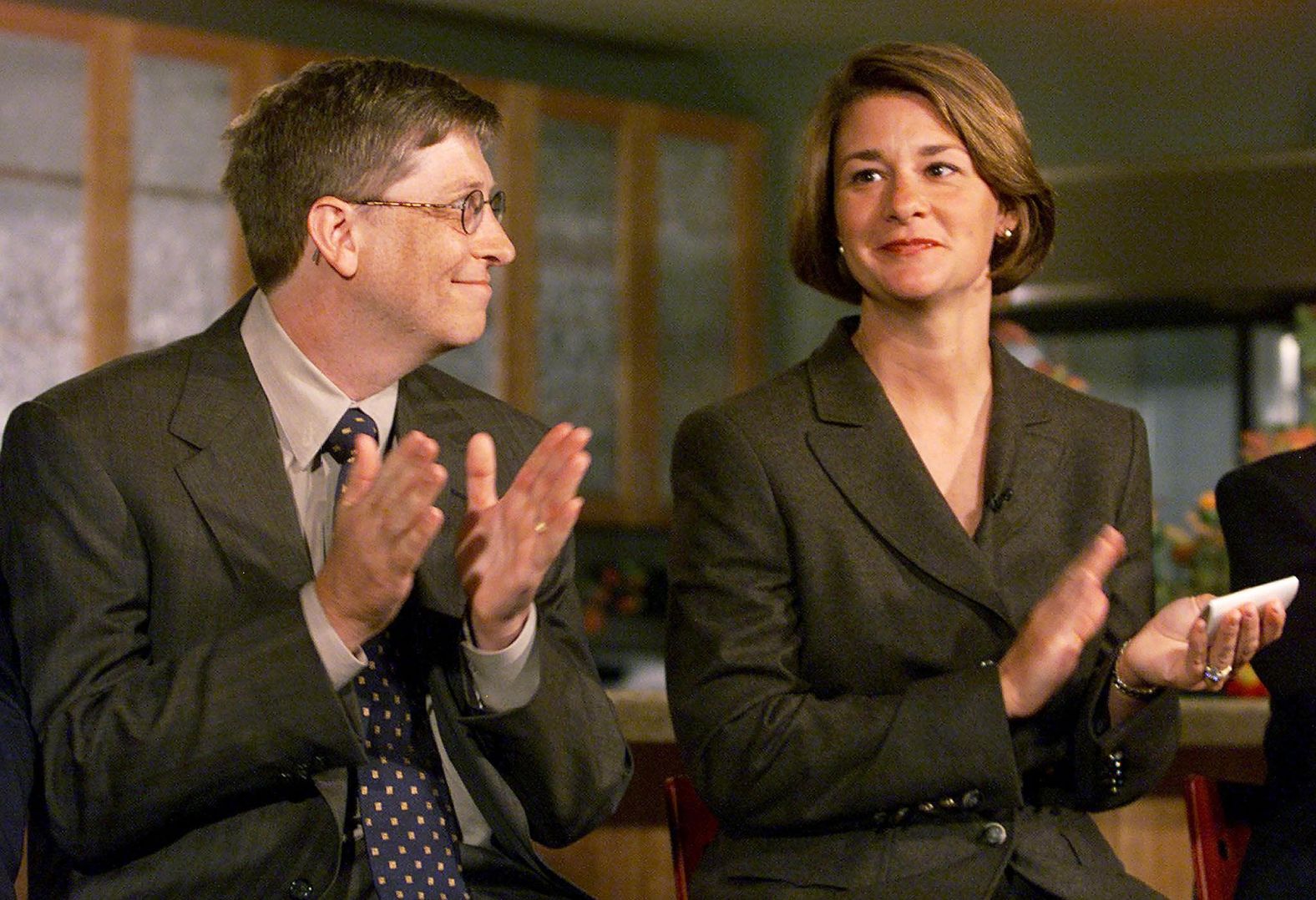 Gates looks at his wife, Melinda, at a 1998 news conference as they announce the Millennium Scholars Program that would provide financial assistance to high-achieving minority students who would otherwise be excluded from higher education. Through 2023, the Bill & Melinda Gates Foundation has issued more than $77 billion in grant payments to charitable causes.