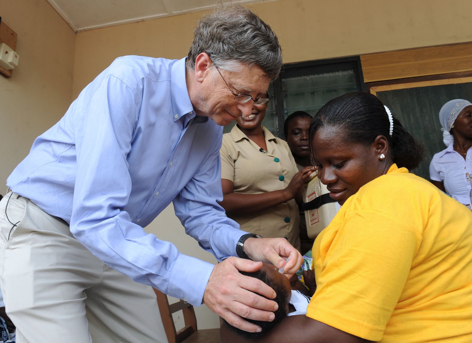 Gates gives a child a rotavirus vaccine while visiting Ghana in 2013.
