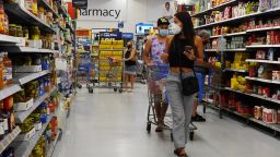 People wearing protective masks shop in a Walmart store on May 18, 2021 in Hallandale Beach, Florida. Walmart announced that customers who are fully vaccinated against Covid-19 will not need to wear a mask in its stores, unless one is required by state or local laws. The announcement came after the Centers for Disease Control and Prevention said that fully vaccinated people do not need to wear a mask or stay 6 feet apart from others in most cases, whether indoors or outdoors. (Photo by Joe Raedle/Getty Images)