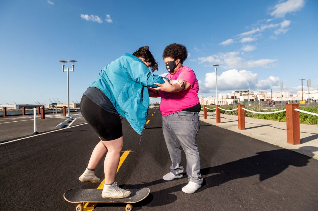 Andy Duran (R) helps Bella Bond learn to skate during the first Chub Rollz event.