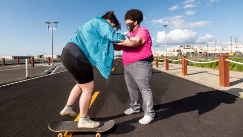 Andy Duran (R) helps Bella Bond learn to skate during the first Chub Rollz event.
