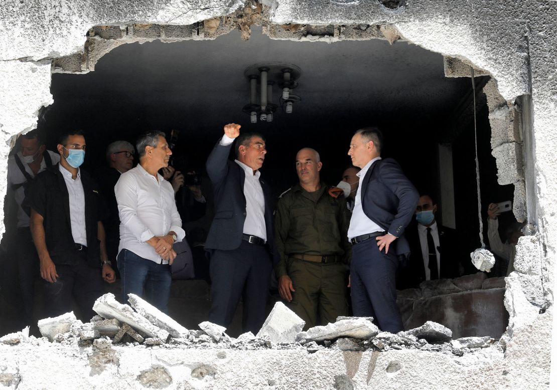 German Foreign Minister Heiko Maas, right, listens to his Israeli counterpart, Gabi Ashkenazi, center, during a visit Thursday to a building in the Israeli city of Petah Tikva that was hit by rocket fire.