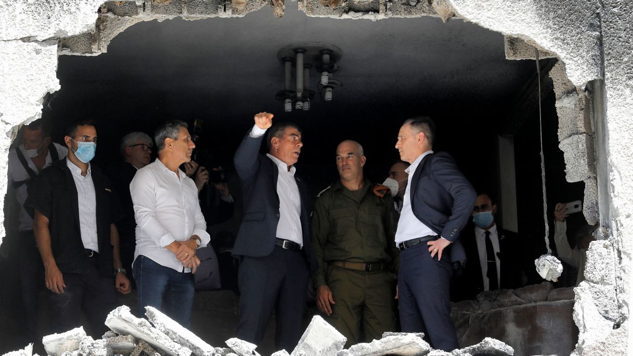 German Foreign Minister Heiko Maas, right, listens to his Israeli counterpart, Gabi Ashkenazi, center, during a visit Thursday to a building in the Israeli city of Petah Tikva that was hit by rocket fire.