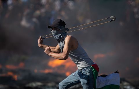 A Palestinian clashes with Israeli forces at the Hawara checkpoint, south of the West Bank city of Nablus, on Tuesday, May 18.