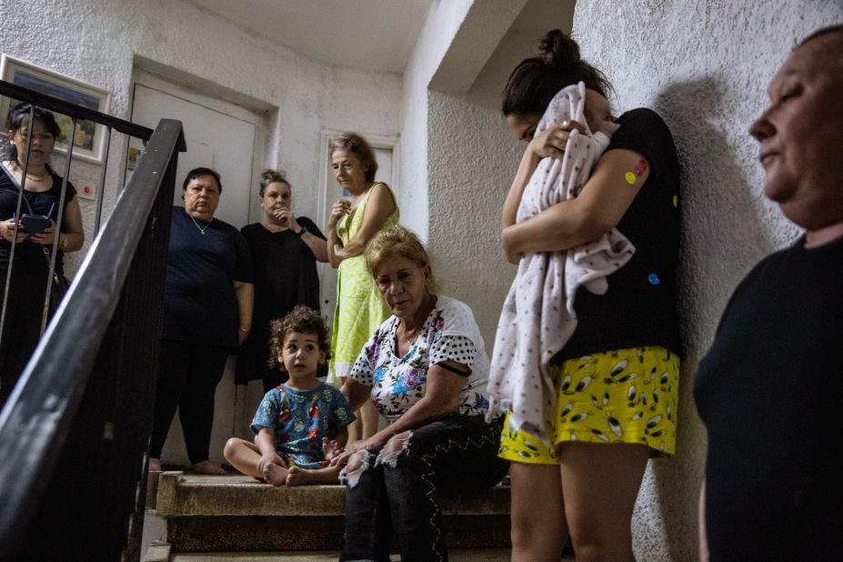 Israelis take shelter in the stairwell of their apartment building in Ashdod, Israel, as a siren sounds to warn of incoming rockets from Gaza on Wednesday, May 19.