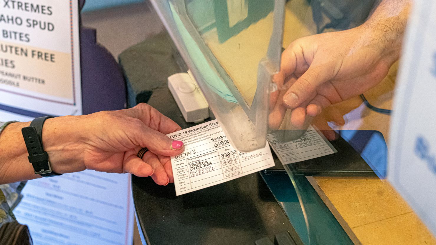 A woman presents her vaccine card at Liberty Theatre in Camas, Washington, on May 14 after Gov. Jay Inslee announced that the statewide mask mandate would no longer apply to fully vaccinated adults.