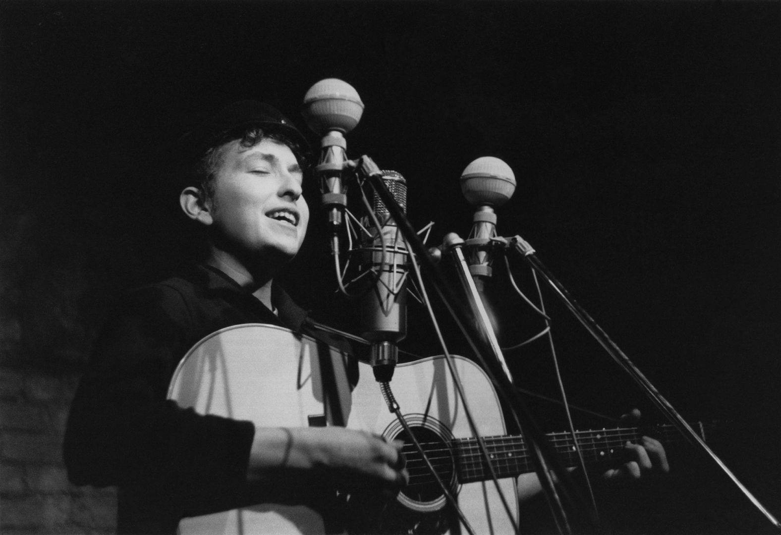 Dylan performs at The Bitter End folk club in New York City in 1961. His first album, "Bob Dylan," came out in 1962 and consisted mostly of old folk songs.