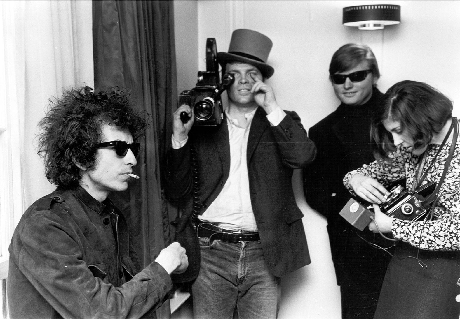 Dylan smokes a cigarette as D.A. Pennebaker films "Don't Look Back," a documentary film about Dylan's tour of England in 1965.