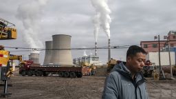 A person walks past a coal fired power plant in Jiayuguan, Gansu province, China, on Thursday, April 1, 2021. 