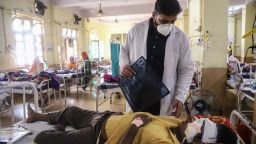 A doctor assists a Covid-19 coronavirus patient with Black Fungus, a deadly and rare fungal infection, as he receives treatments at the NSCB hospital in Jabalpur, on May 20, 2021. (Photo by Uma Shankar MISHRA / AFP) (Photo by UMA SHANKAR MISHRA/AFP via Getty Images)